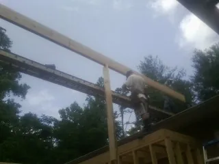 Carpenter setting a ridge beam over a new addition frame — Ice Dam Removal by Roofing Brothers in Audubon